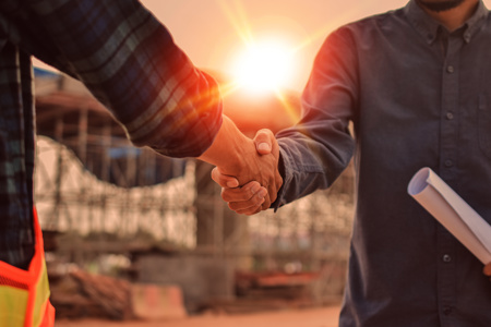 Construction site meeting with a handshake